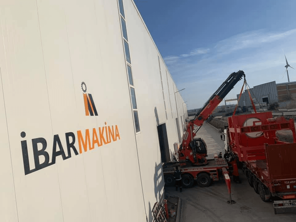 Üzerinde İBAR MAKİNA logosu bulunan üretim tesisi ve vinç